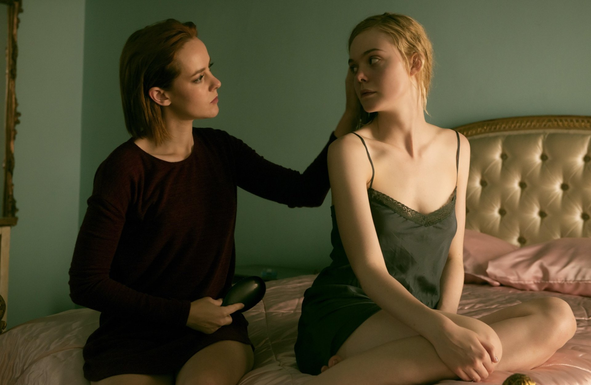 Jena Malone and Elle Fanning share an intimate moment in a scene from the movie The Neon Demon, featured in an HD PC desktop wallpaper and background.