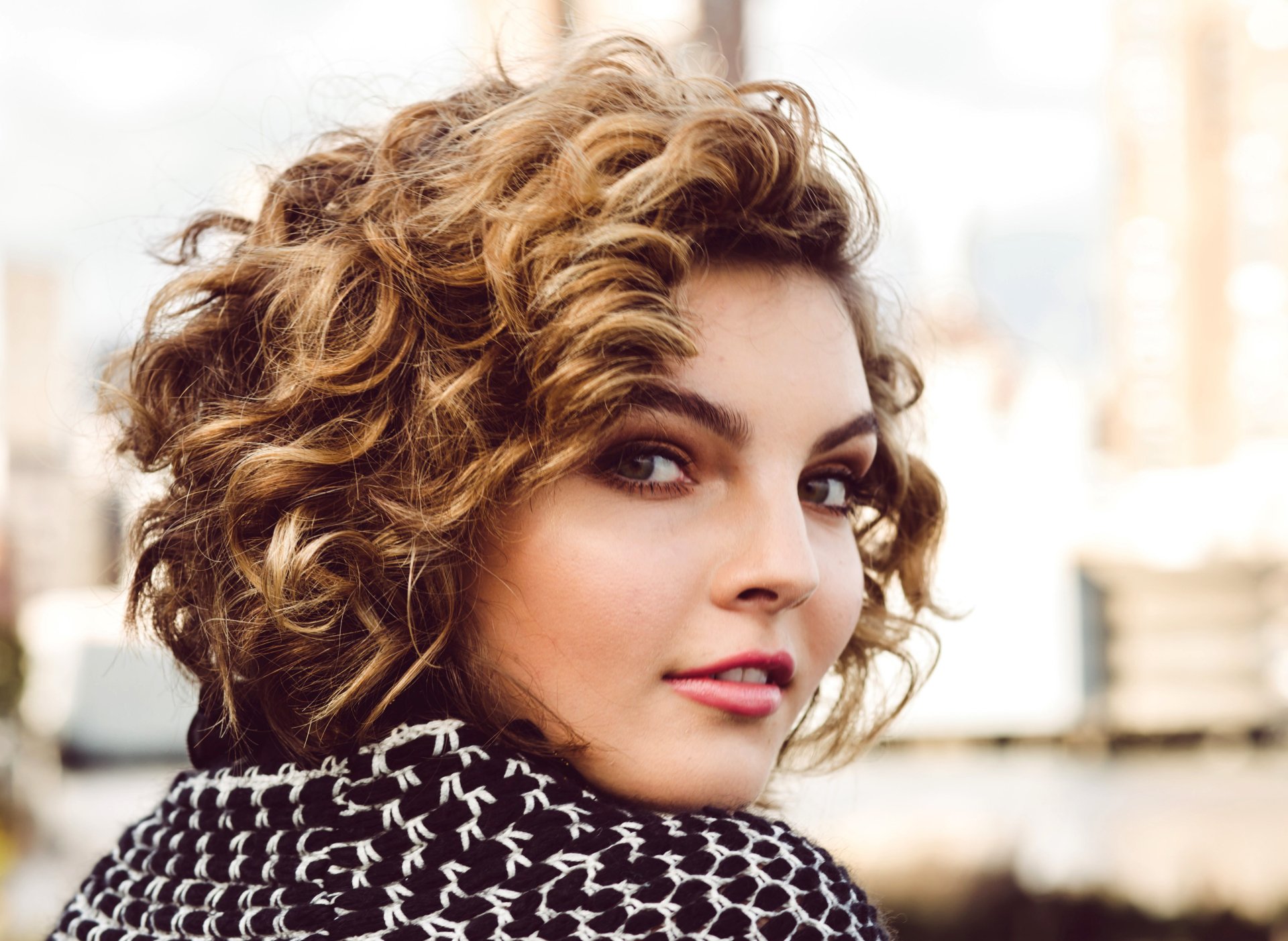 Close-up portrait of American actress Camren Bicondova with hazel eyes and curly brunette hair, featured in a 4K Ultra HD PC desktop wallpaper.