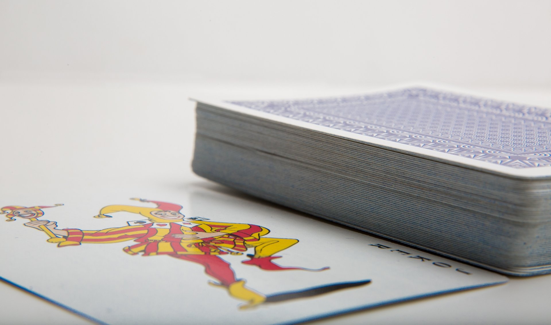 A close-up of a colorful jester playing card next to a deck of cards, showcased as a 4K Ultra HD PC desktop wallpaper and background.
