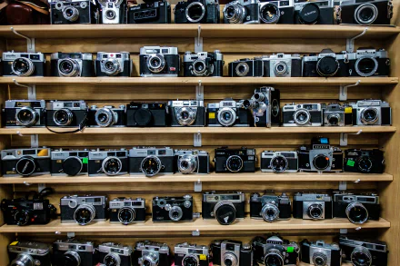 HD desktop wallpaper featuring a collection of vintage man-made cameras neatly arranged on wooden shelves.