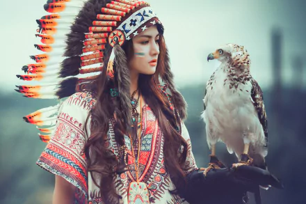 A Native American woman with long brunette hair and traditional headdress gazes at an eagle perched on her gloved hand. The image is a high-definition desktop wallpaper and background.