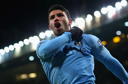 Sergio Agüero in a Manchester City F.C. jersey celebrates during a soccer match, captured in a dynamic 4K Ultra HD desktop wallpaper.