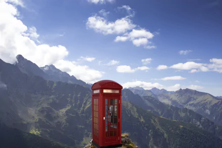 A red phone box stands on a mountain peak under a blue sky with clouds, captured in a 4K Ultra HD manipulated scenic desktop wallpaper.