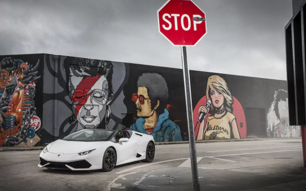 White Lamborghini Huracán LP 610-4 supercar parked by a colorful mural and stop sign under a dramatic sky — 4K Ultra HD PC desktop wallpaper background