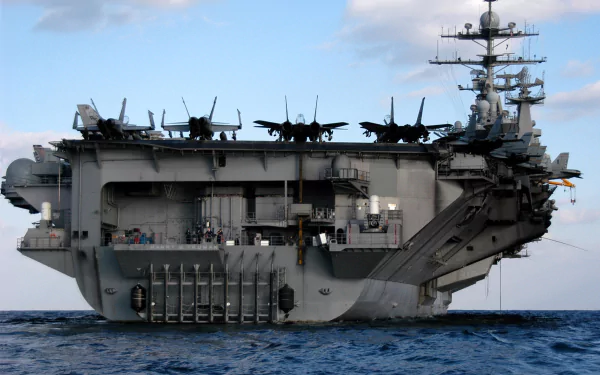 HD desktop wallpaper of the USS Harry S. Truman (CVN-75) aircraft carrier at sea, showcasing the naval military ship and its parked aircraft on deck.