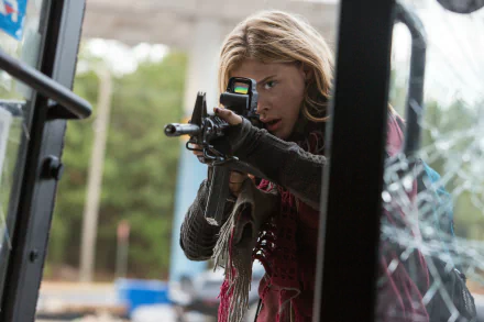 Chloë Grace Moretz in a scene from the movie The 5th Wave, aiming a gun through a broken window, featured as a 4K Ultra HD PC desktop wallpaper.
