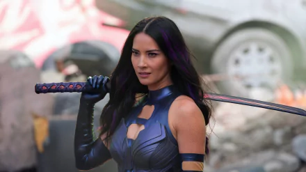 Olivia Munn portrays Psylocke in X-Men: Apocalypse, holding her sword confidently amidst a chaotic backdrop, captured in stunning 8K Ultra HD detail.