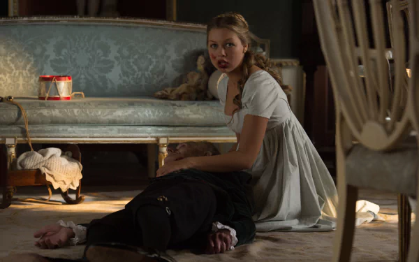 Movie still — Pride and Prejudice and Zombies: a woman in Regency dress kneels beside a fallen man in a dim parlor scene. 4K Ultra HD PC desktop wallpaper/background.