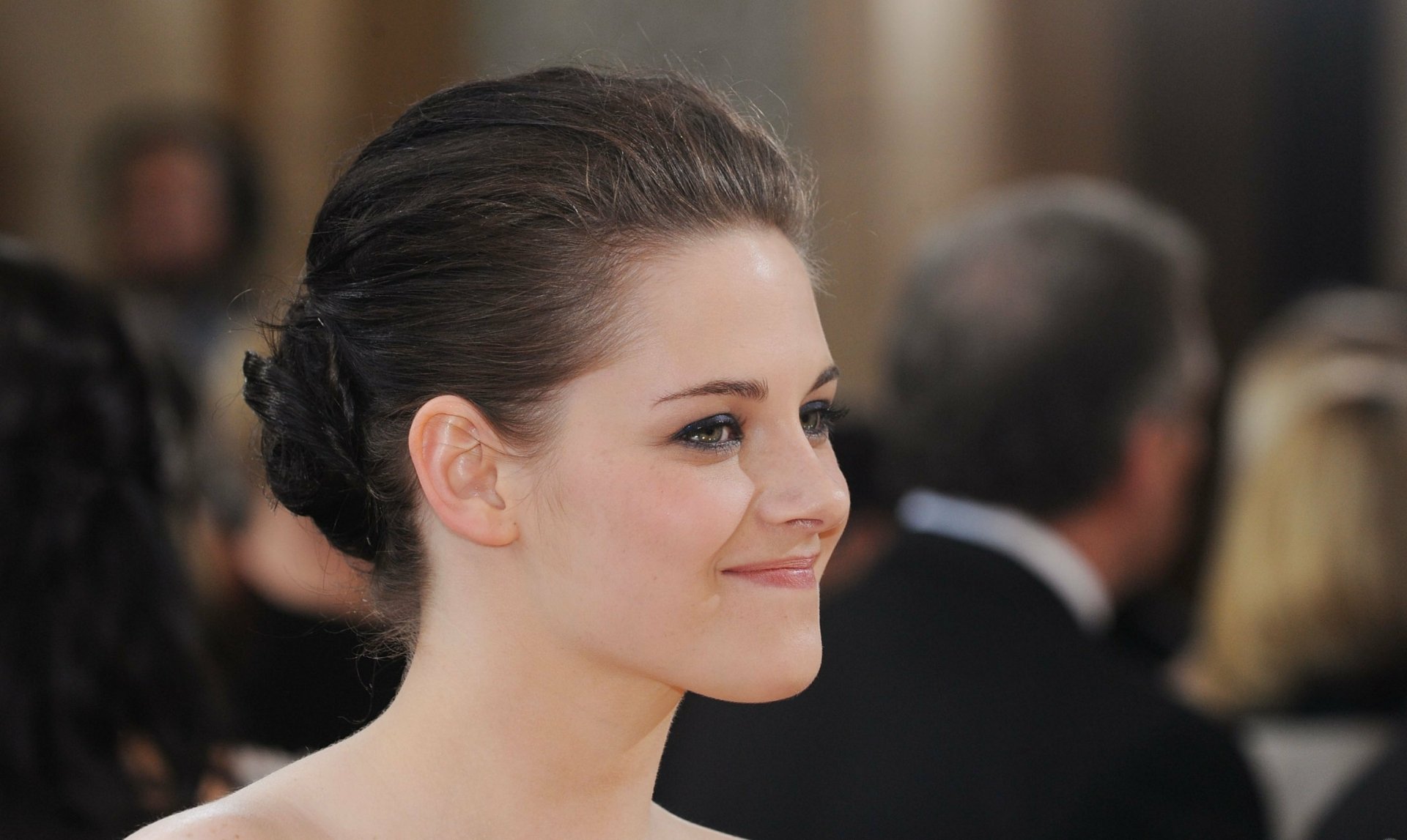 HD PC desktop wallpaper featuring a close-up portrait of celebrity Kristen Stewart with a soft smile, set against a blurred background.
