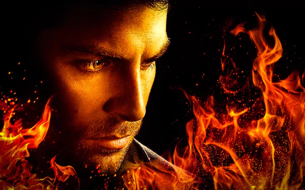 A dramatic HD wallpaper featuring a close-up of a man's intense expression surrounded by flames, inspired by the TV show Grimm.