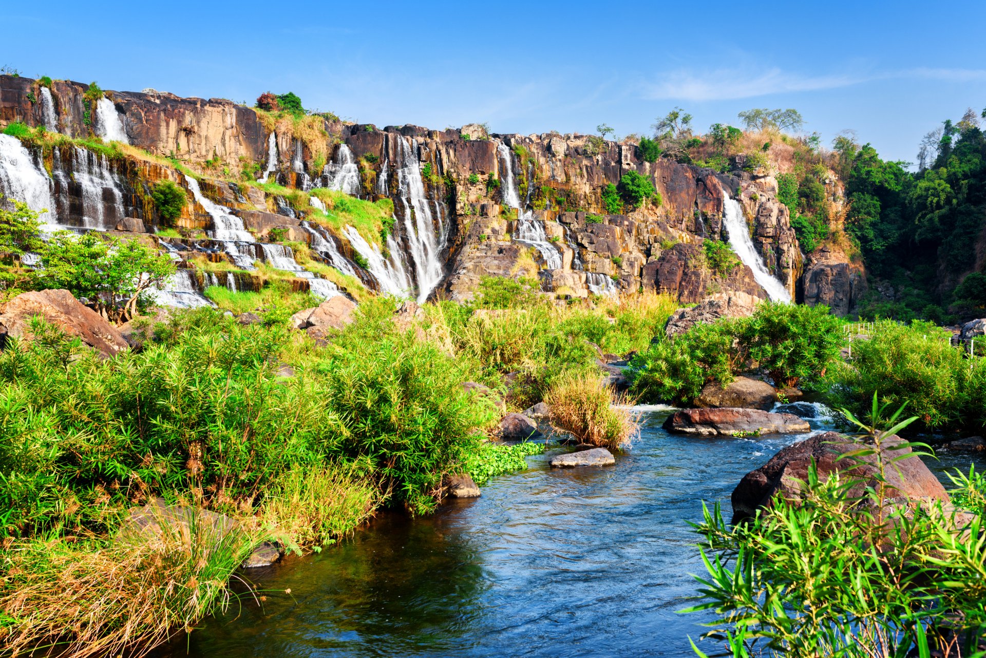 A vibrant 4K Ultra HD image of lush greenery and cascading waterfalls in Vietnam, blending natural beauty with a rock & roll energy for a dynamic desktop wallpaper.