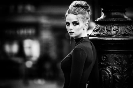 Black and white HD desktop wallpaper of a female model with an intense gaze, styled hair, and high contrast lighting against an ornate background.