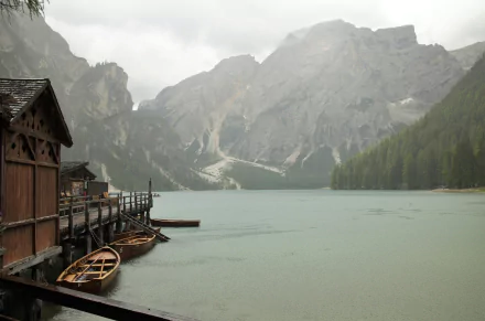 4K Ultra HD landscape of a misty mountain wilderness with a lake, wooden boat dock, and rain-soaked scenery captured in stunning photography.
