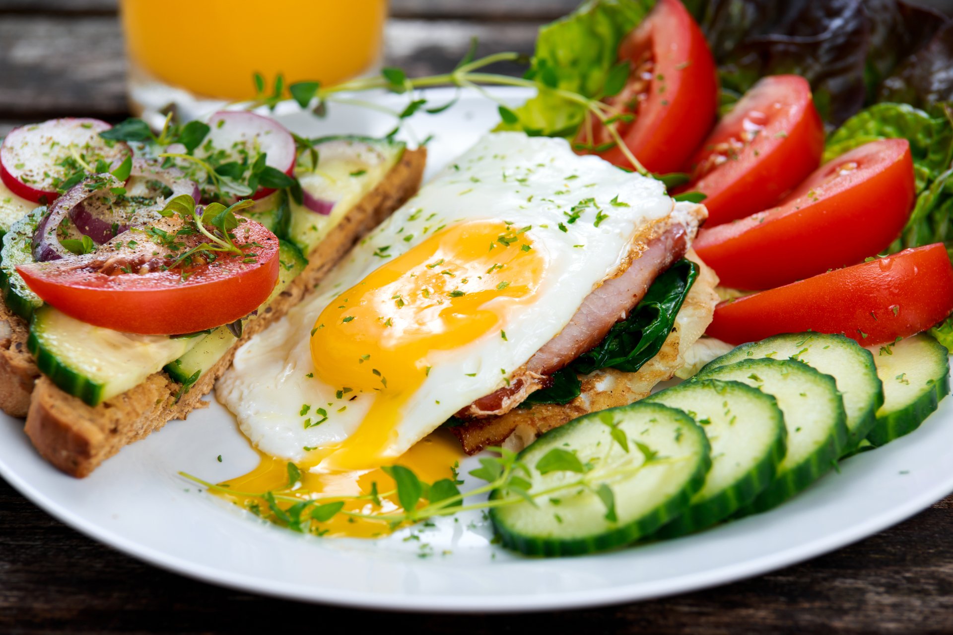 5K Ultra HD PC desktop wallpaper of a fresh meal: fried egg with runny yolk on toast, sliced tomato and cucumber, salad greens and herbs.