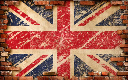HD desktop wallpaper featuring a distressed Union Jack flag painted on a brick wall with chipped and weathered textures.