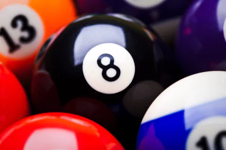A close-up of a billiard ball collection, featuring the iconic black eight ball surrounded by colorful cue balls. This vibrant image serves as a captivating 4K Ultra HD desktop wallpaper.