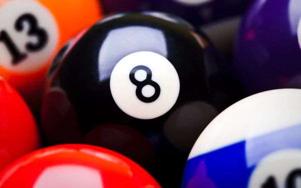 A close-up of a billiard ball collection, featuring the iconic black eight ball surrounded by colorful cue balls. This vibrant image serves as a captivating 4K Ultra HD desktop wallpaper.