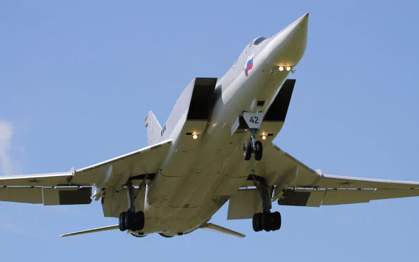 Tupolev Tu-22 bomber warplane in flight, low-angle view of the military aircraft against a clear blue sky — HD PC desktop wallpaper/background.