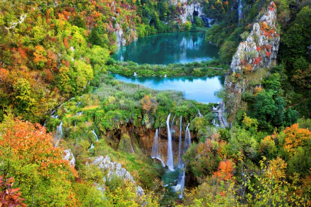 A stunning view of Plitvice Lake National Park in autumn, featuring vibrant foliage, tranquil waters, and cascading waterfalls, creating a vibrant forest landscape.