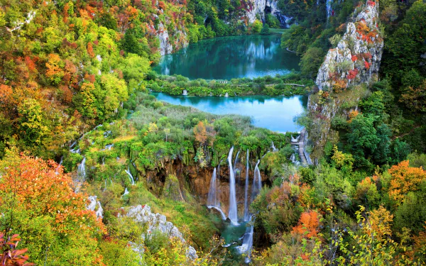 A stunning view of Plitvice Lake National Park in autumn, featuring vibrant foliage, tranquil waters, and cascading waterfalls, creating a vibrant forest landscape.