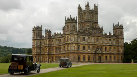 HD desktop wallpaper featuring the iconic Downton Abbey castle from the TV show, showcasing its grand architecture under a cloudy sky.