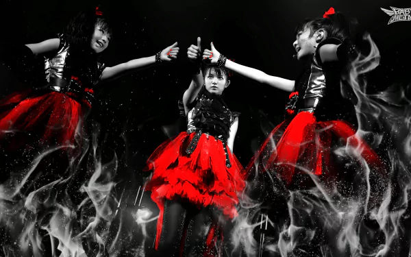 Japanese metal idol group Babymetal performs energetically in red and black outfits, surrounded by smoky effects, captured in a dramatic 4K Ultra HD heavy metal wallpaper.