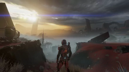 A stunning HD wallpaper depicting Scott Ryder from Mass Effect: Andromeda, standing against a dramatic alien landscape under a moody sky, with distant structures and a glowing sunset.