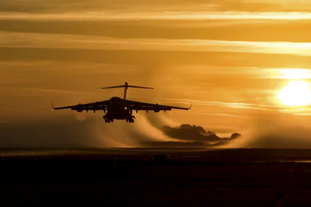 Silhouette of a Boeing C-17 Globemaster III military transport aircraft flying at sunset, captured as an HD PC desktop wallpaper and background.