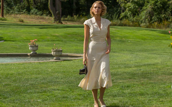 Woman in a vintage cream dress walks across a manicured lawn in a scene from the movie Cafe Society — 4K Ultra HD PC desktop wallpaper/background.