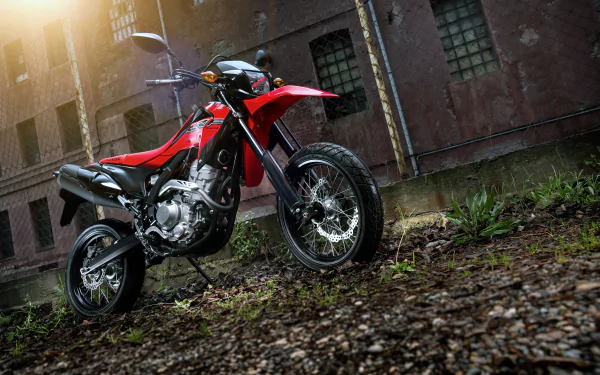 Red Honda CRF250M motorcycle parked on gravel with a building in the background, captured in 4K Ultra HD for a PC desktop wallpaper.