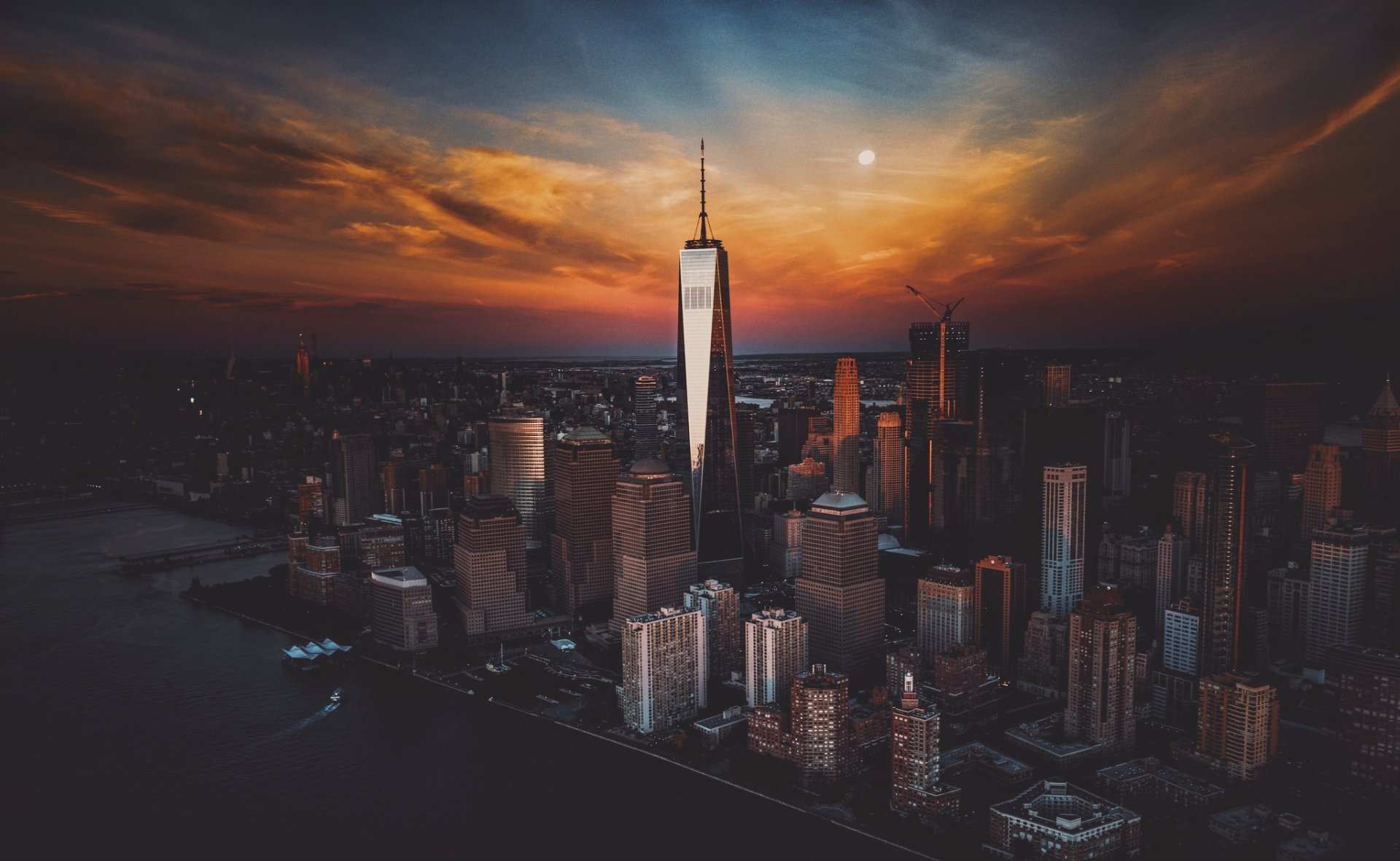 Aerial view of Manhattan's skyscrapers at sunset, showcasing the vibrant sky and iconic cityscape of New York, USA in stunning HD detail.