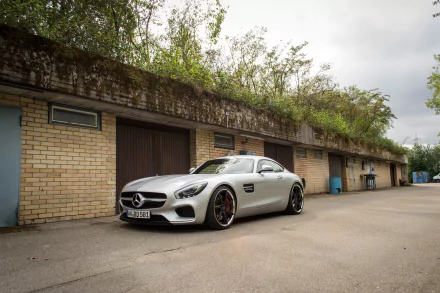 Silver Mercedes-AMG GT parked in front of a brick building, captured in a high-resolution 4K Ultra HD desktop wallpaper showcasing the sleek vehicle design.