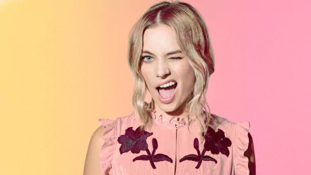Image of Australian actress Margot Robbie with blue eyes and blonde hair, winking playfully against a gradient background of yellow and pink. This HD desktop wallpaper captures her vibrant personality.