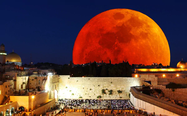 A vibrant blood moon rises over a city skyline at night, blending natural lunar beauty with urban architecture in this HD PC desktop wallpaper.