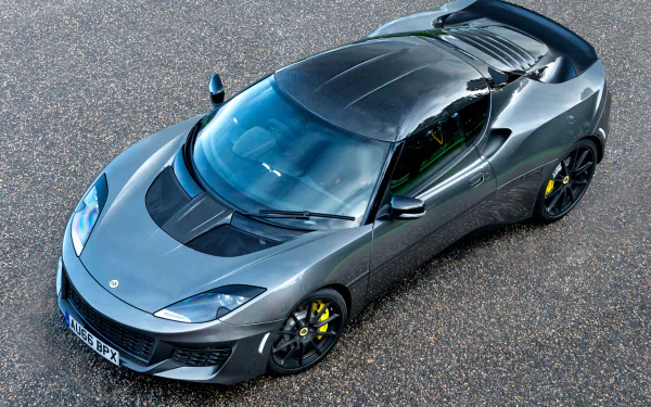 Silver Lotus Evora supercar captured in 4K Ultra HD, showcasing sleek design details and aerodynamic curves on a textured asphalt background.