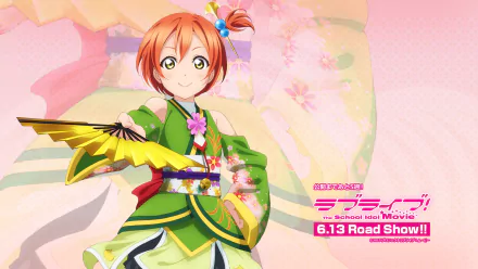 HD PC desktop wallpaper featuring Rin Hoshizora from the anime Love Live!, dressed in a vibrant green outfit with a fan, set against a soft pink floral background.