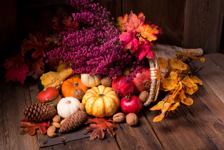 A fall-themed still life featuring a cornucopia spilling vibrant leaves, pine cones, gourds, walnuts, pomegranates, and pumpkins, captured in 4K Ultra HD photography.