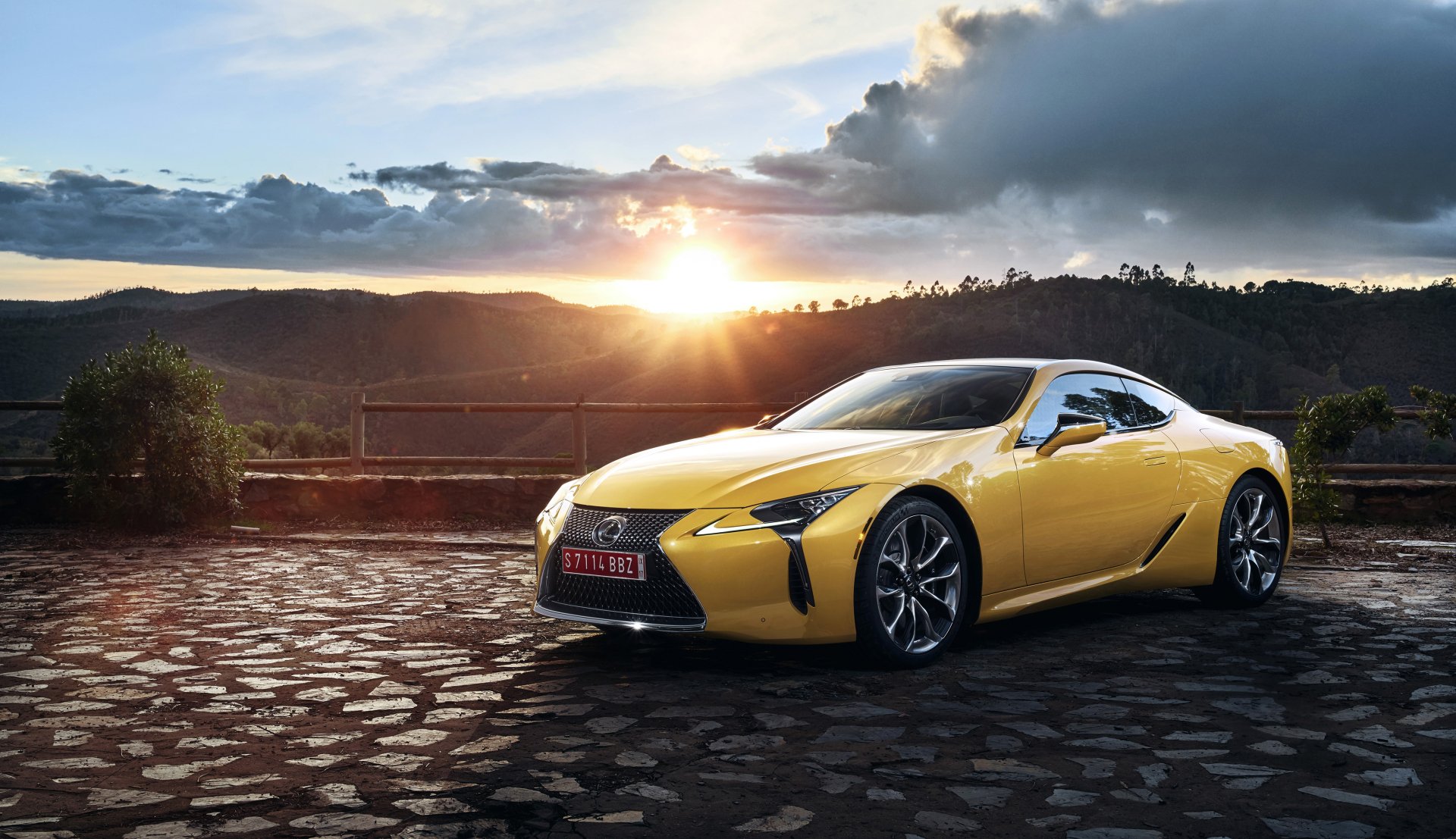Yellow Lexus LC 500 grand tourer parked on cobblestone at sunrise with dramatic sky — 4K Ultra HD PC desktop wallpaper background
