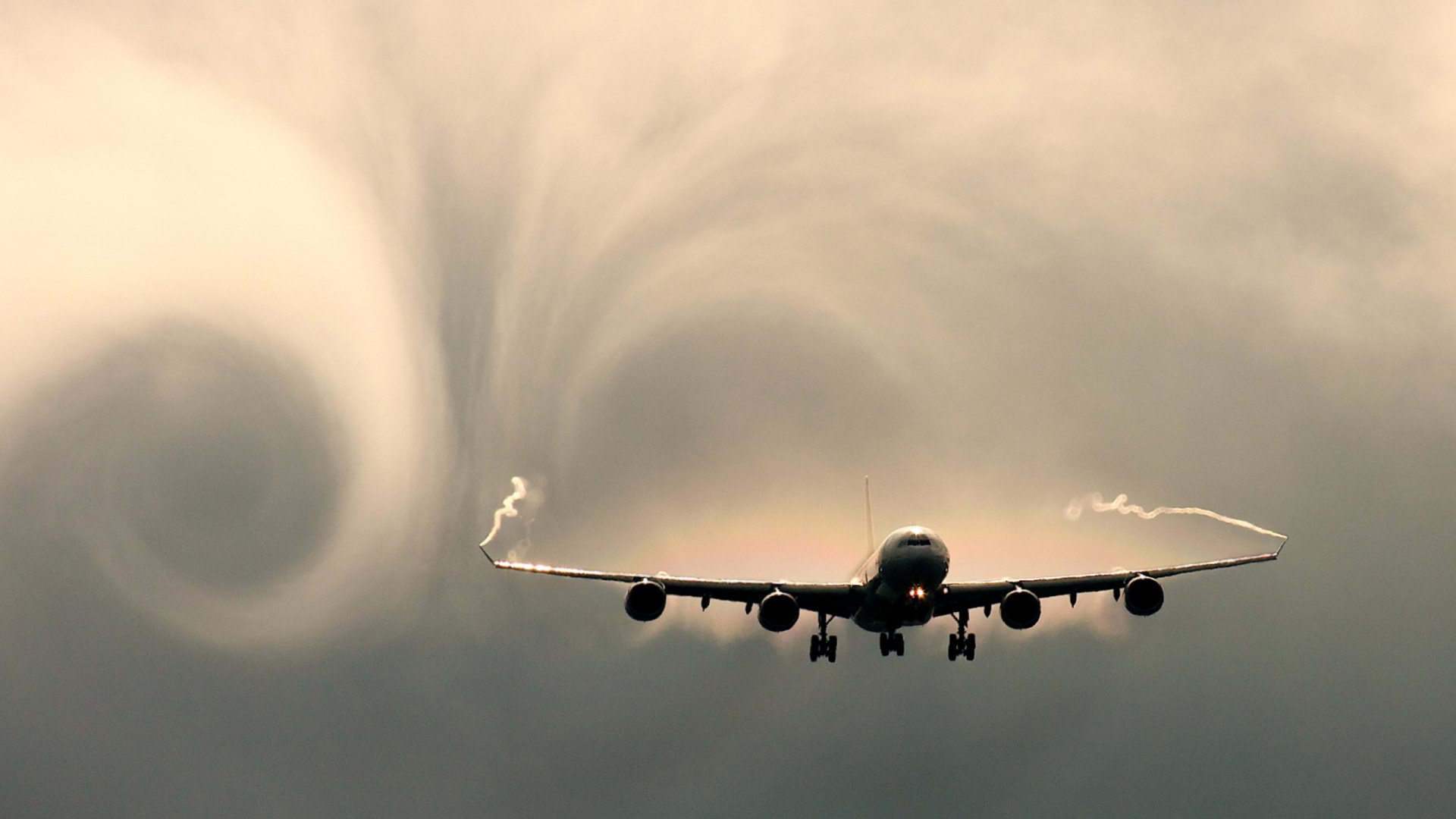 HD PC desktop wallpaper showing a large aircraft flying through cloudy skies with swirling vortex patterns near its wings.