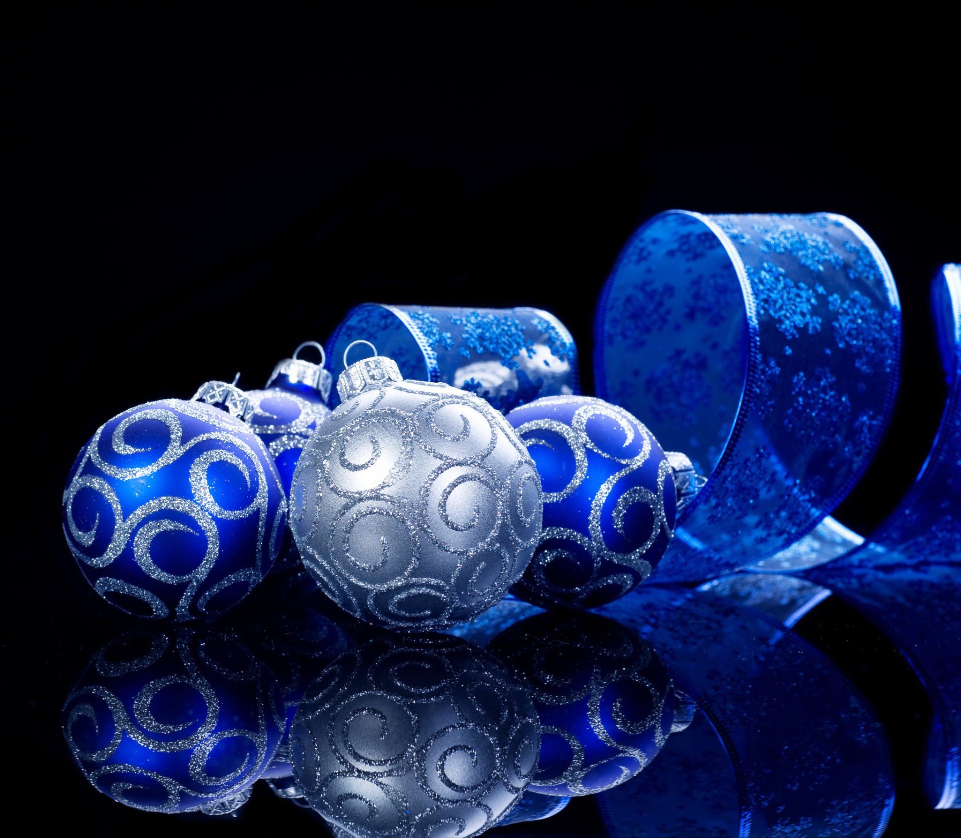 HD desktop wallpaper featuring silver and blue Christmas ornaments with a matching blue ribbon against a dark background, creating a festive holiday atmosphere.