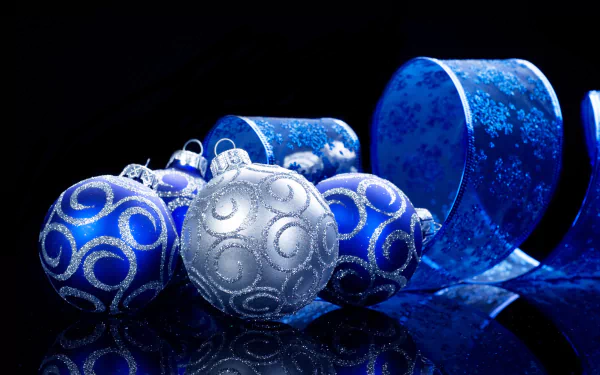 HD desktop wallpaper featuring silver and blue Christmas ornaments with a matching blue ribbon against a dark background, creating a festive holiday atmosphere.