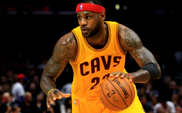 HD desktop wallpaper featuring a basketball player in a yellow Cavs jersey dribbling during a game.