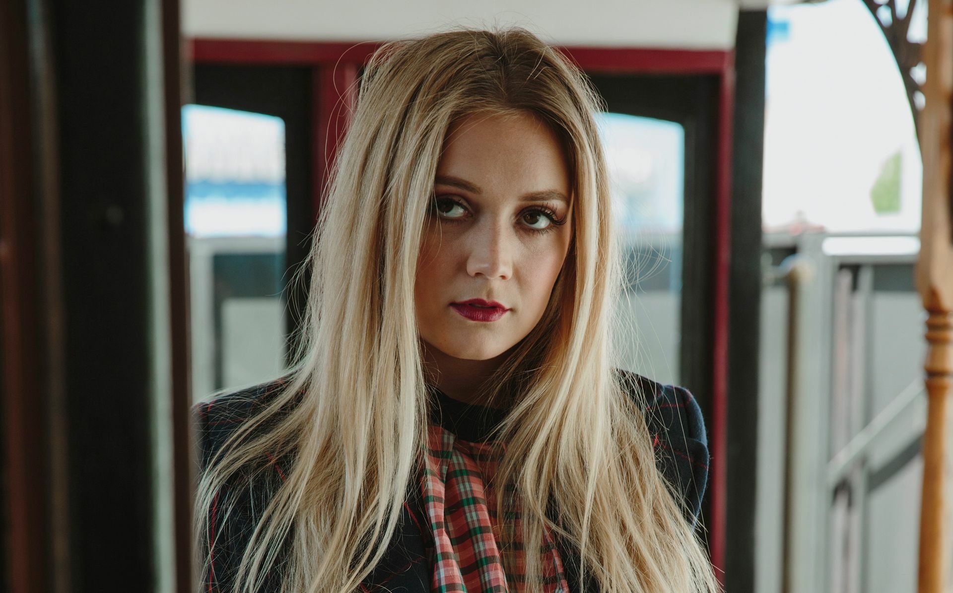 HD desktop wallpaper featuring a close-up portrait of blonde actress and model Billie Lourd with a serious expression and natural lighting.