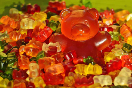 A vibrant 4K Ultra HD desktop wallpaper featuring a large red gummy bear surrounded by smaller multicolored gummy bears, highlighting colorful food candy.