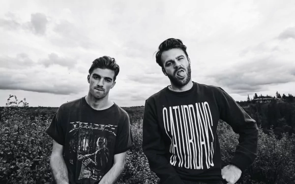 HD desktop wallpaper featuring a monochrome photo of the music duo The Chainsmokers posing outdoors.