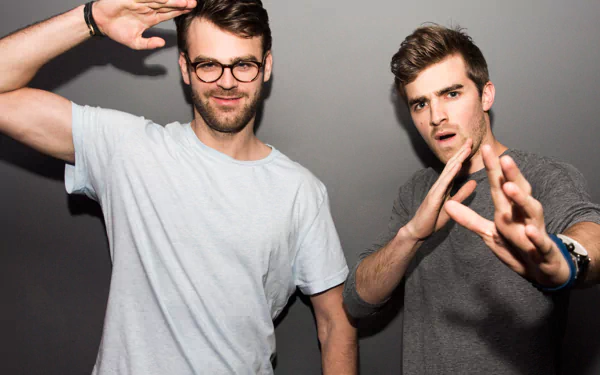 HD desktop wallpaper featuring The Chainsmokers posing with playful hand gestures against a gray background.