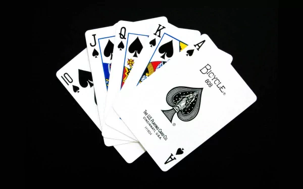 A close-up image of a straight flush in spades from a Bicycle deck of cards. The cards are neatly fanned out against a black background, making a striking HD desktop wallpaper.