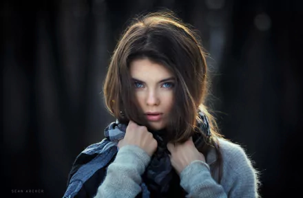 HD desktop wallpaper featuring a brunette woman with striking blue eyes, captured in a moody, high-definition portrait.