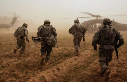 Military personnel run toward Sikorsky UH-60 Black Hawk helicopters in a dusty landscape, captured in HD for a PC desktop wallpaper background.