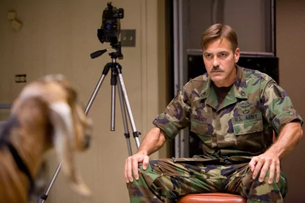 Male actor in camouflage seated in a sparse interrogation room, scene from the movie The Men Who Stare at Goats — 4K Ultra HD PC wallpaper/background.